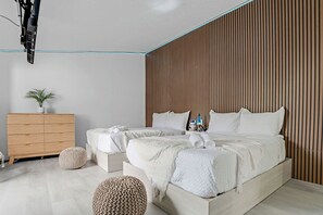 Ein modernes Schlafzimmer mit einem großen Bett, Nachttischen, einem Holzschrank und einem Blumentopf.