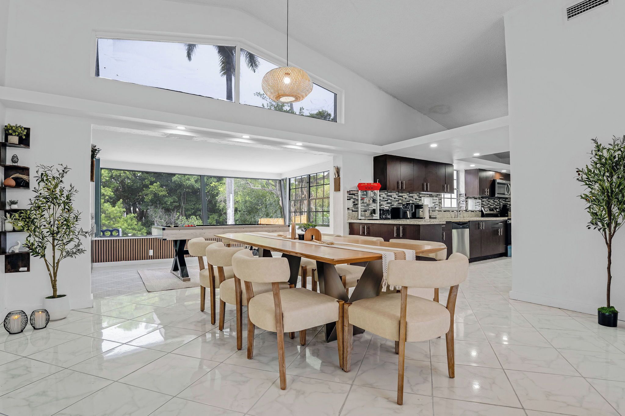 A modern kitchen with dark cabinets, stainless steel appliances, and a large island with seating.