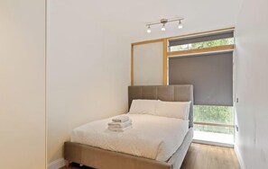 A bedroom with a bed, a window, and a ceiling light fixture. - Modern City Centre Apt with Balcony in Dublin 1 (Dublin)