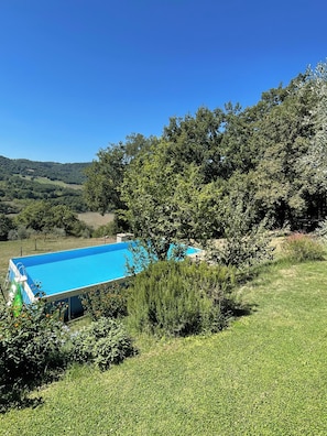 A swimming pool surrounded by lush greenery and hills in the background. - The Casalino Orvieto Dépendance. A hidden oasis surrounded by greenery, 15 minutes from Orvieto (Umbria)