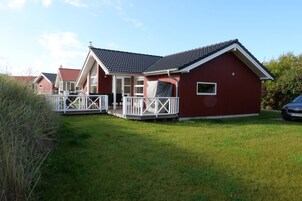 A red building with a porch and a covered outdoor seating area.