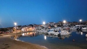 A marina with boats docked, surrounded by buildings and a calm water body.