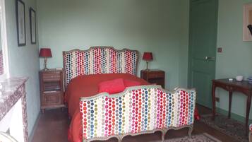 Una camera da letto con un letto, comodini, una lampada e una porta.