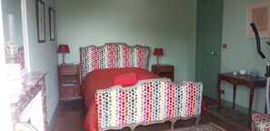 A bedroom with a bed, bedside tables, a lamp, and a door.