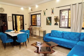 A dining area with a table and chairs, a sofa, and a coffee table.