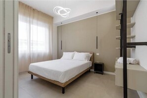 Ein modernes Schlafzimmer mit einem Bett, einem Nachttisch, einer eingebauten Bank und einer Treppe.