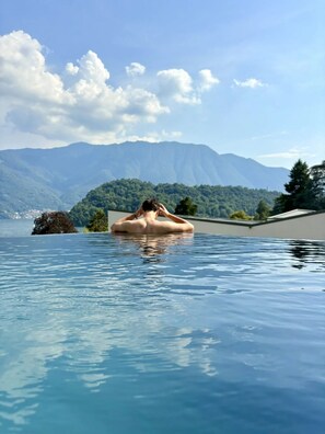 Une personne dans une piscine, avec un paysage montagneux en arrière-plan.