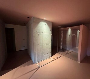 A modern interior with a concrete accent wall, a glass partition, and a metal frame structure. - Villa Aqua by Elite Villas (Tremezzina)