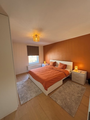 A bedroom with a bed, bedside tables, a window with blinds, and a ceiling light fixture. - Family home with a garden. Brussels is a 9-minute train ride away. Near Hallerbos (Halle)