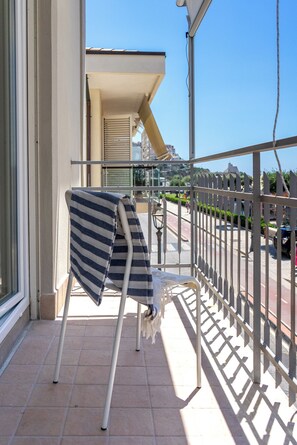 A balcony with a metal railing, a chair, and a striped towel draped over it. - Casa Canzatora (Sperlonga)