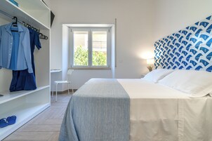 Una camera da letto con un letto, un armadio, una finestra e una sedia.