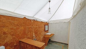 A bathroom with a stone wall, a wooden vanity, a sink, and a mirror.