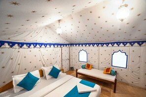A tented room with two beds, star-patterned walls, and a canopy.