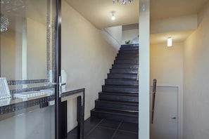 A staircase leading to a landing with a light fixture above it. - Oceanview Oasis - Close to CBD and Airport (Sandy Bay)