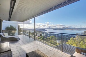 En balkon med udsigt over vand og fjerne bjerge.