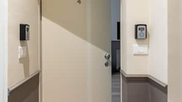 A hallway with a door marked with the number 4, a doorbell, and a light switch on the wall.