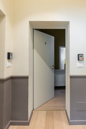 Ein Hotelzimmer mit einer Tür, auf der die Zahl '3' steht, die zu einem Badezimmer führt.