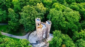 A castle-like structure surrounded by dense greenery. - Historic 3BDR with Sky Lounge in Greenwich (Greater London)