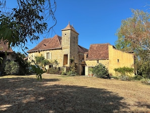 A stone building with a tower, surrounded by dry grass and trees. - Bread Oven. Peace and quiet in rural Lot. (Uzech)