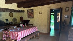 Un comedor rústico con mantel a cuadros, bancos de madera y una pared de piedra.