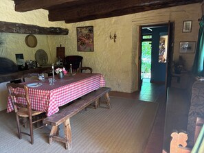 A rustic dining area with a checkered tablecloth, wooden benches, and a stone wall. - Bread Oven. Peace and quiet in rural Lot. (Uzech)
