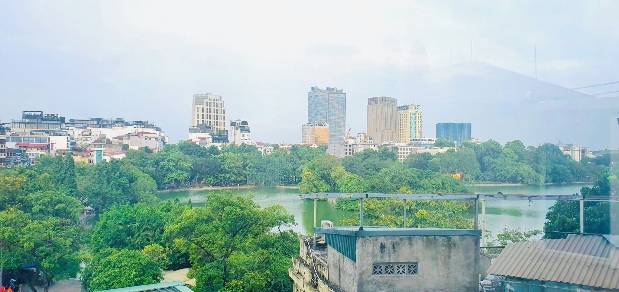 A cityscape with a river, buildings, and greenery.