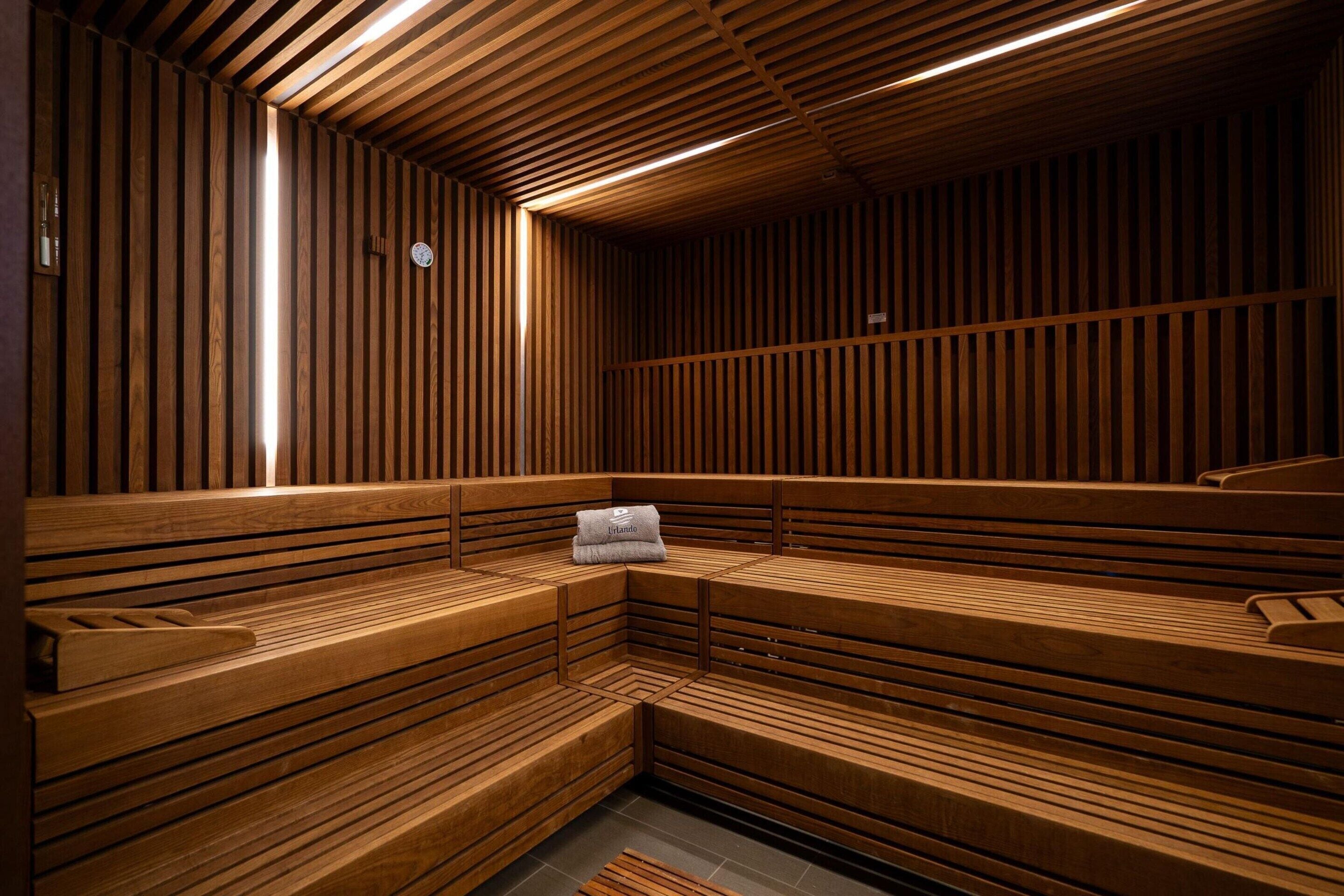 Un sauna avec des bancs en bois et une serviette posée sur l’un d’eux.