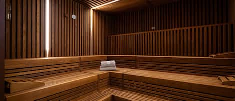Uma sauna com bancos de madeira e uma toalha sobre um deles.