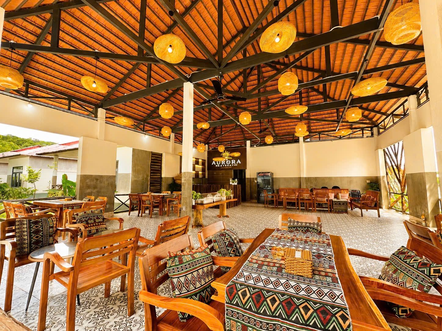 A spacious indoor area with wooden furniture and hanging lights.