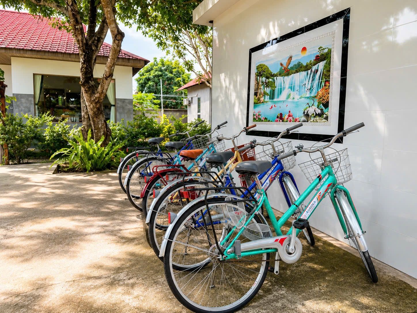 Diverse biciclette parcheggiate contro un muro, con un quadro incorniciato sopra.