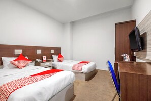 A hotel room with two beds, a desk, a television, and a minibar. - Collection O Loc Binh Hotel Near Da Lat (Xuan Huong Ward, Da Lat)
