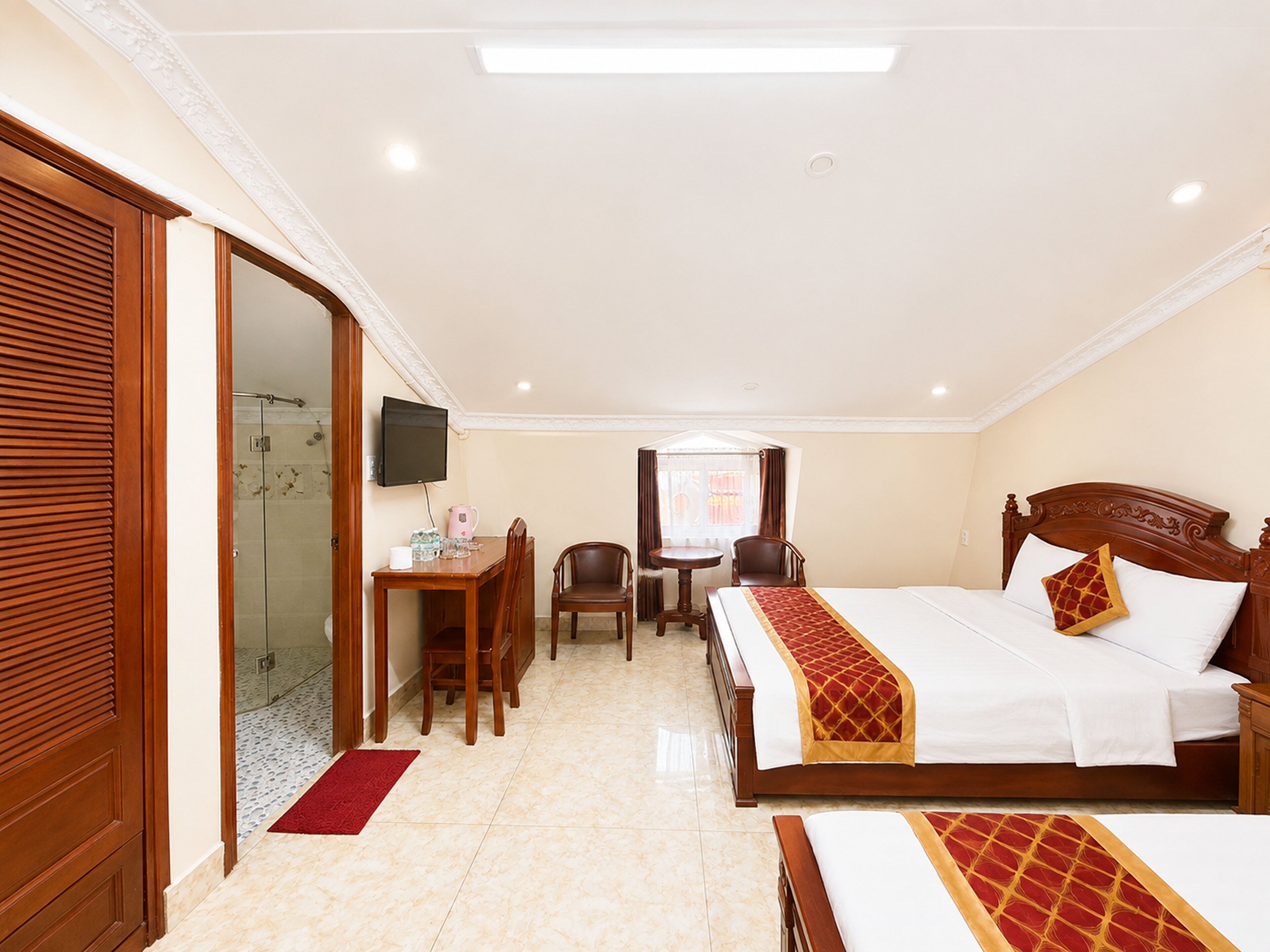 Une chambre d’hôtel comprenant un lit, un bureau avec une chaise, une télévision et un espace douche.