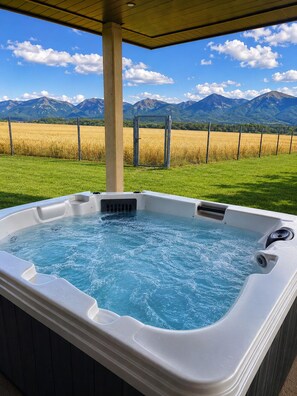 Un bain à remous avec vue sur les montagnes et un champ.