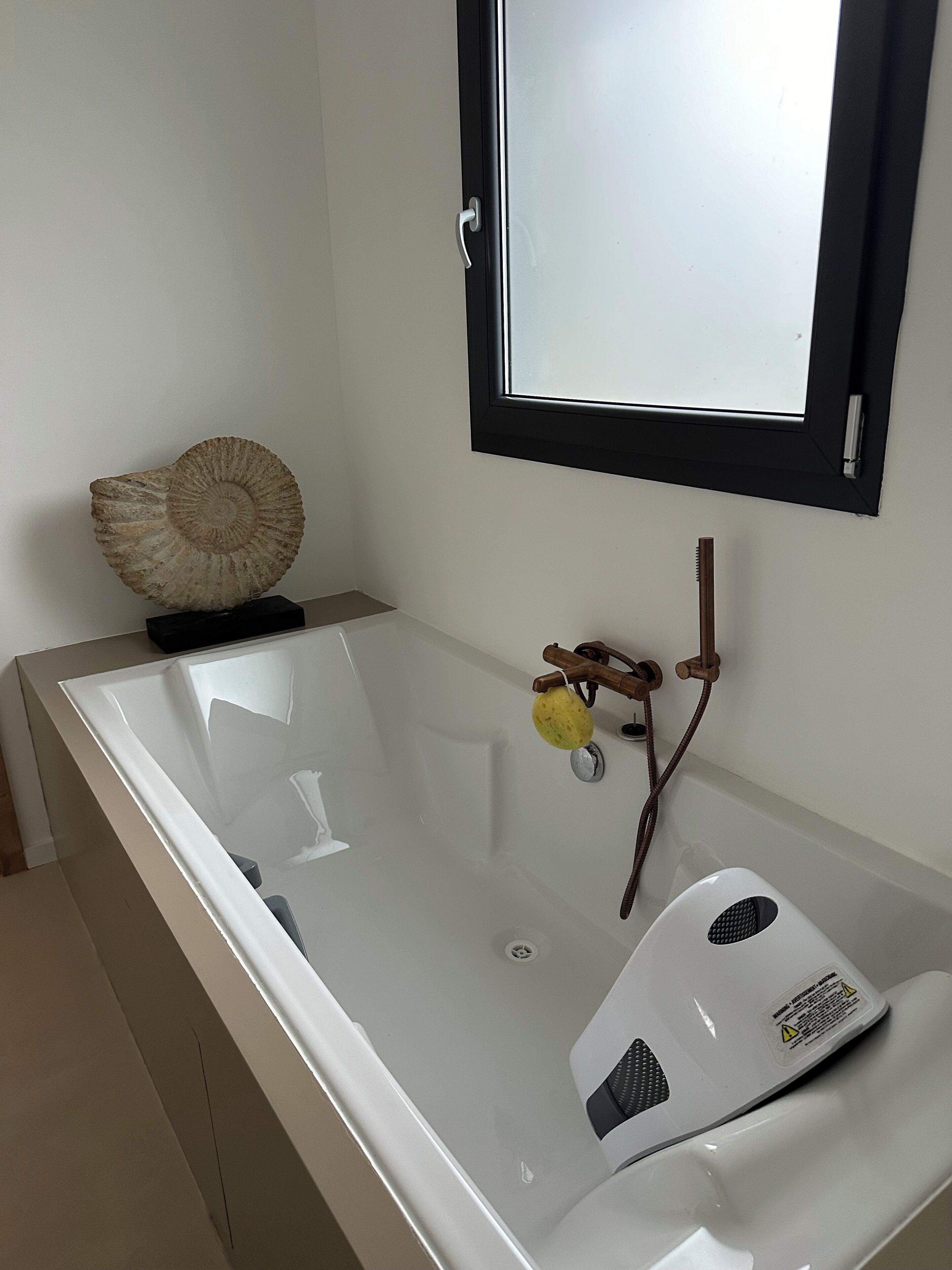 Ein Badezimmer mit einer Badewanne, einem Spiegel und einer Dekoration aus einer Muschel.