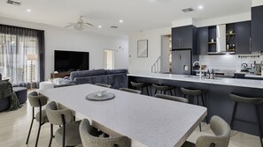 A modern kitchen with dark cabinets, a white countertop, and a built-in stove. - Coastal Clover - 7 James Drive (Carrickalinga)