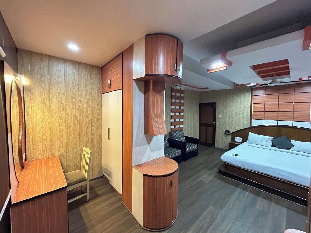 Una habitación de hotel con cama, escritorio, silla y armario.