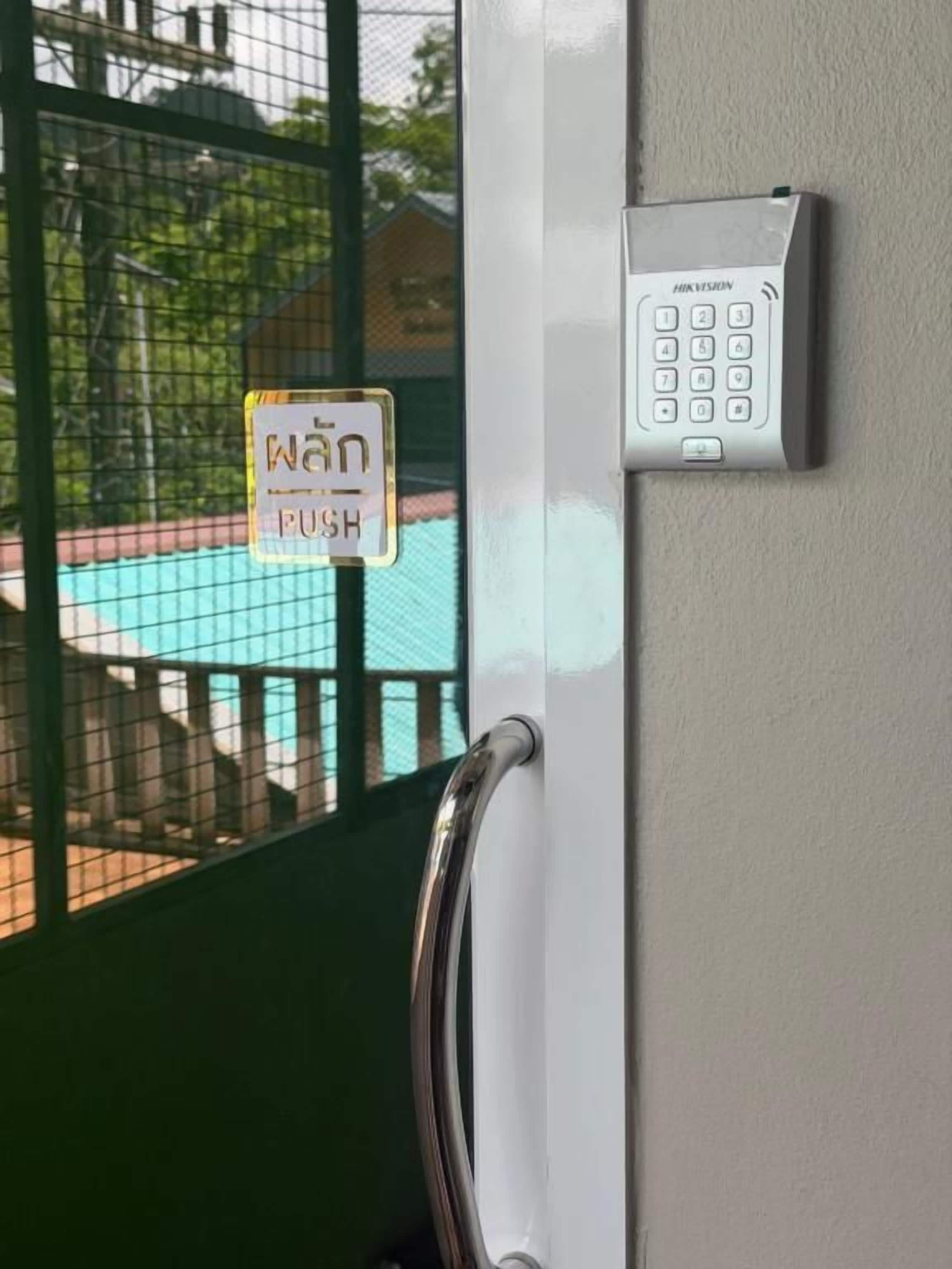 Una puerta con cerradura electrónica y un letrero con botón pulsador.