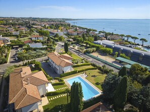 Ein Wohngebiet mit einem großen Schwimmbad, einer Straße und Blick auf das Meer.