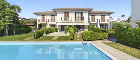 A two-story building with a swimming pool in front.