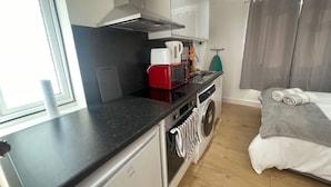 Una cocina compacta equipada con microondas, tostadora y lavadora.