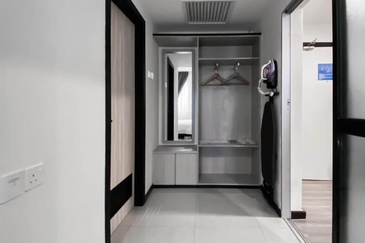 A corridor with a wardrobe, a mirror, and a door leading to another room.