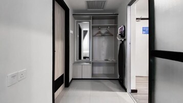 A corridor with a wardrobe, a mirror, and a door leading to another room.