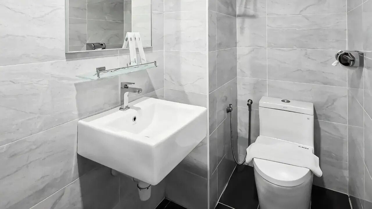 A bathroom with a white sink, mirror, and toilet.