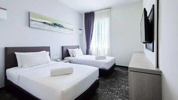 A hotel room with two beds, a flat-screen TV, and a painting on the wall.