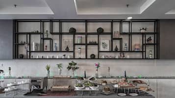 A modern kitchen with a black shelving unit displaying various kitchenware and decorative items.