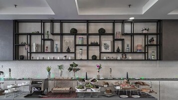 Una cocina moderna con una estantería negra que exhibe diferentes utensilios de cocina y objetos decorativos.