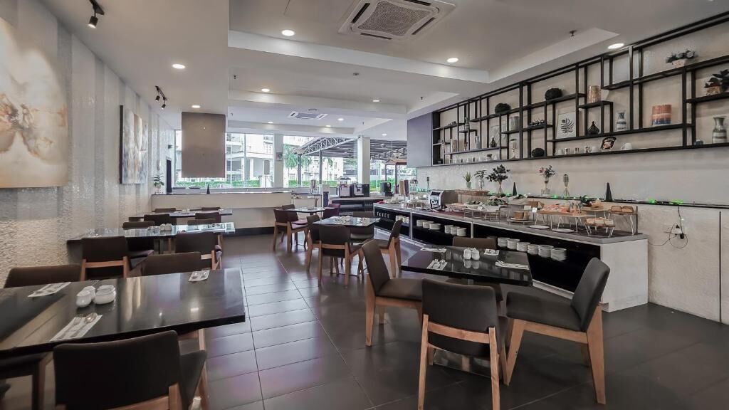 Un restaurante moderno con área de bar, distintas opciones de asientos y vistas al exterior.