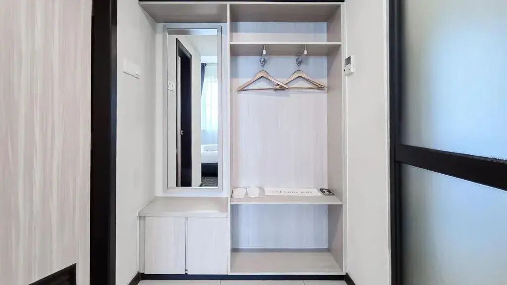 A walk-in closet with a mirror, hanging space, and shelves.