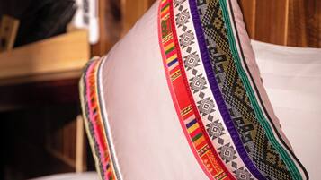 A pillow with a colorful embroidered border and a cushion with a similar design.