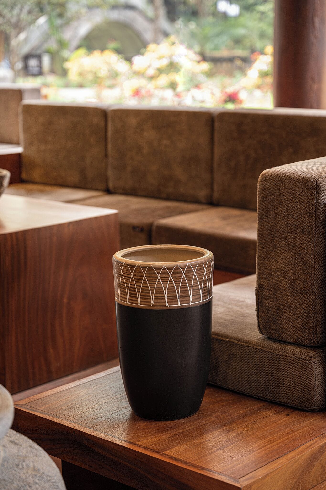 Een tafel met een zwartbruine textuur en een geometrisch patroon, geplaatst op een houten ondergrond.